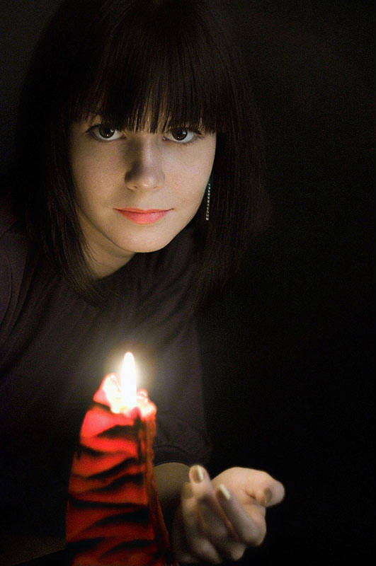 Портретная фотосессия девушки брюнетки в темноте при свечев фотостудии фотограф Борис Никитин 